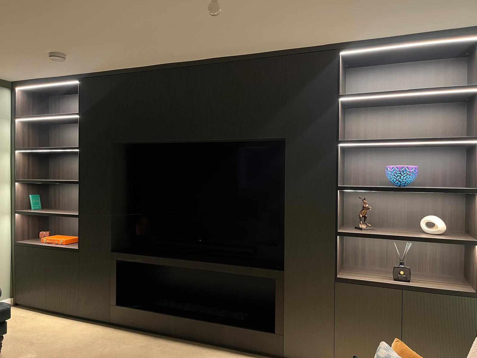 A bespoke media wall with recessed television and lit shelving, installed by Allview